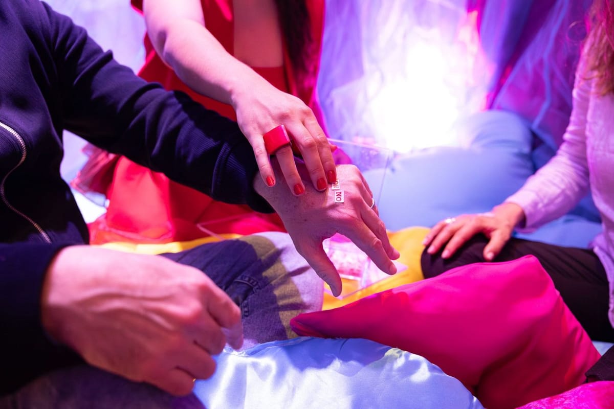 A small NO sticker being placed on the back of a hand